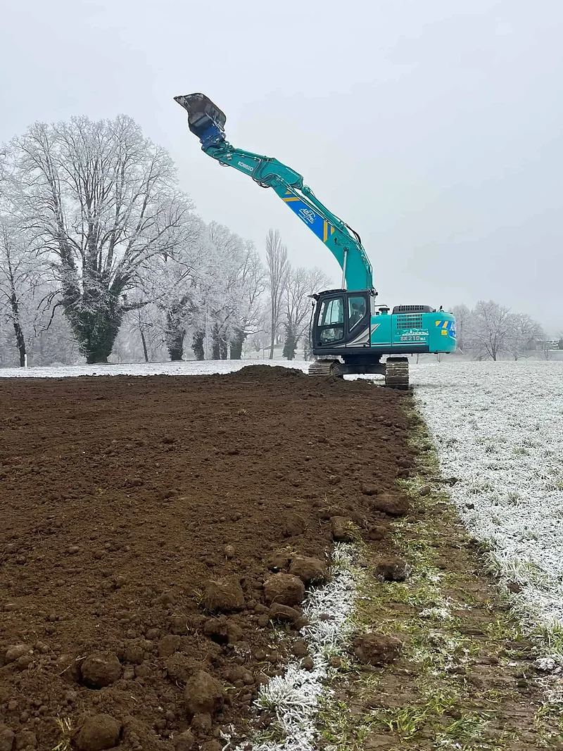 Kobelco-Bagger beim Humusabtrag im Winter