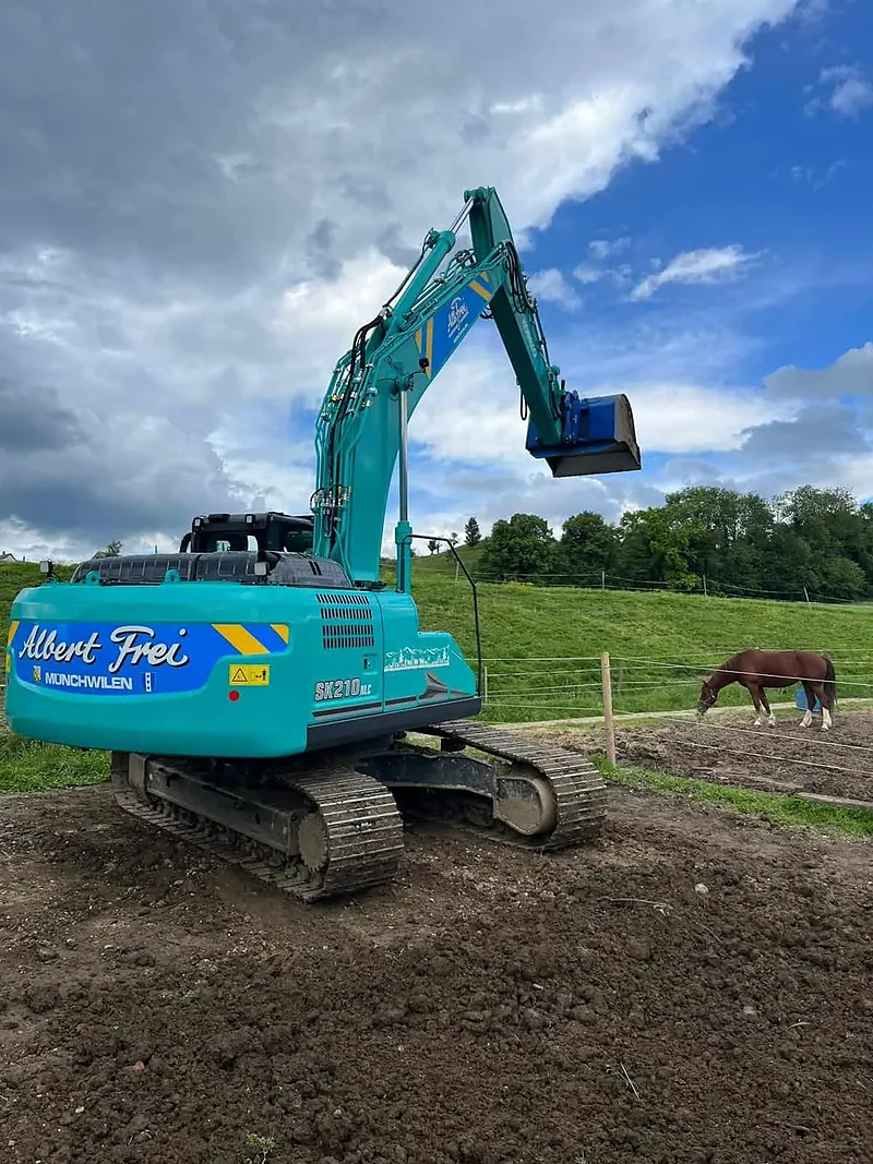 Kobelco-Bagger von Alb. Frei beim Aushub neben einer Pferdeweide