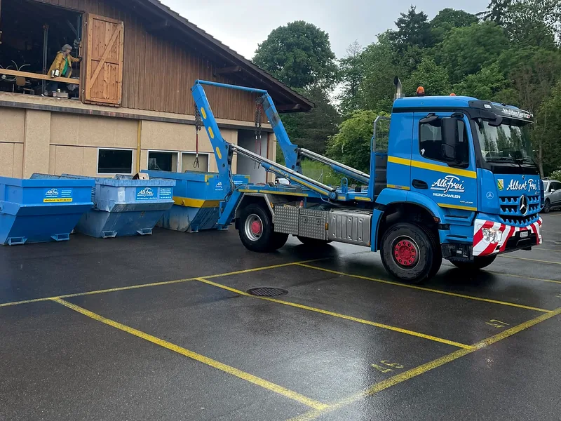 Muldenwagen stellt Welaki-Mulden für eine Räumung bereit
